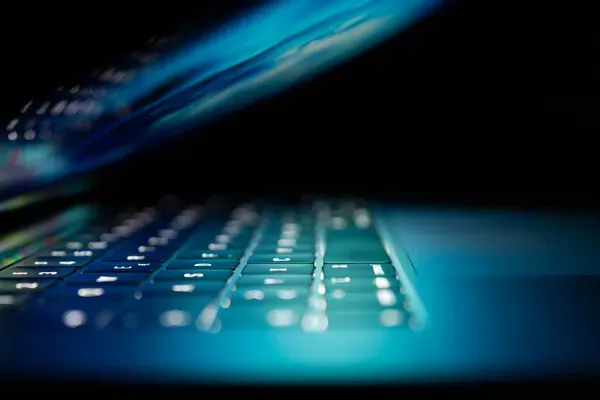 Ordinateur portable ouvert dans un environnement sombre pour supervision informatique